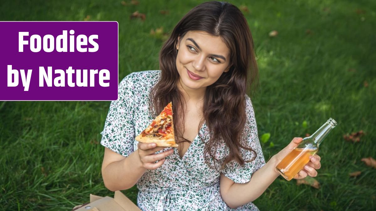 Happy young woman eating pizza at a picnic.